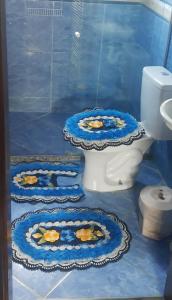 a bathroom with a toilet with flowers on the floor at Pousada Relíquias do Mar in Arraial do Cabo