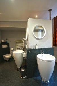 een badkamer met een wastafel, een toilet en een spiegel bij LOFT13 Traumhafte Wohnung mit Terrasse für 4 Gäste in Monschau
