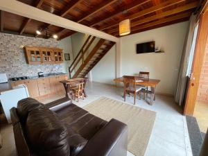 a living room with a leather couch and a table at Loft Maika'i in Santo Antônio do Pinhal