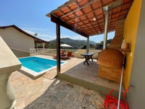 a patio with a swimming pool and a house at Loft Maika'i in Santo Antônio do Pinhal