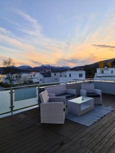 eine Terrasse mit einem Sofa und einem Tisch auf einer Terrasse in der Unterkunft Great villa with amazing view in Tromsø