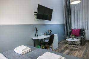 um quarto de hotel com uma cama, uma secretária e uma televisão em Leo Apartments Main Square em Cracóvia