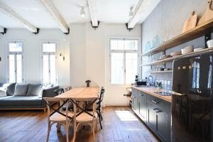 a kitchen with a table and chairs and a couch at Bohemian Valse by HolyGuest in Tel Aviv