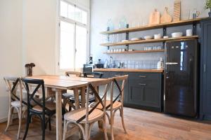 a kitchen with a wooden table and chairs at Bohemian Valse by HolyGuest in Tel Aviv