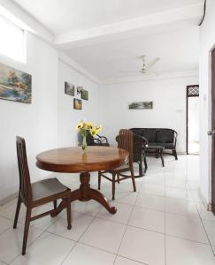 a dining room with a wooden table and chairs at N S Apartment in Mount Lavinia