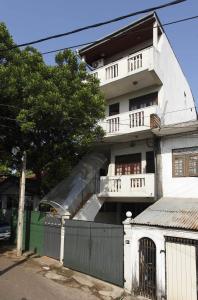 a white building with a fence in front of it at N S Apartment in Mount Lavinia