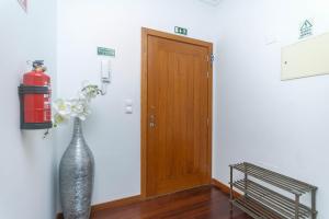 a vase with flowers in it next to a door at Village Lobos Flat in Câmara de Lobos