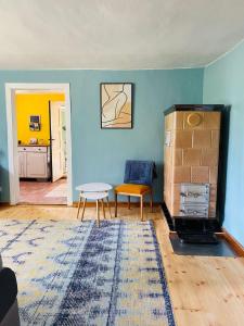 ein Wohnzimmer mit blauen Wänden, einem Tisch und einem Teppich in der Unterkunft Ferienhaus am Seegrund in Ahlbeck