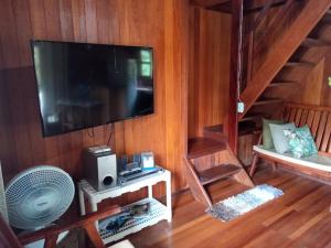 een woonkamer met een grote televisie en een ventilator bij Chalé Da Bia in Cananéia