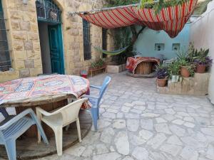 a patio with a table and chairs and an umbrella at Shams House in Amman
