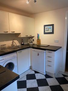 a kitchen with a sink and a washing machine at Cosy Cottage in beautiful Royal Deeside in Aboyne