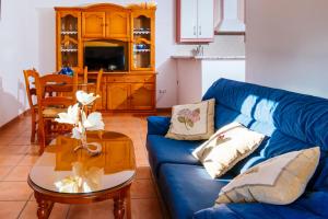 uma sala de estar com um sofá azul e uma mesa em La Atalaya em Frailes