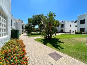 a brick walkway with flowers next to a building at Quiet & Spacious Apt @ Golf Course w/ Roof Terrace in San Roque