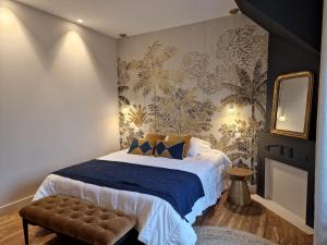 a bedroom with a bed with a blue blanket and a mirror at La touline in Concarneau