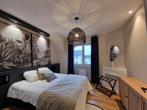 a bedroom with a bed and a pendant light at La touline in Concarneau