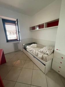 a small bedroom with a bed and a window at 13'S HOME in Caserta