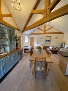a kitchen and living room with wooden ceilings and a table at Old Bunsty, Milton Keynes in Milton Keynes