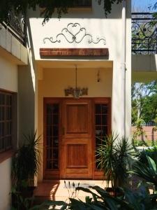 un edificio con una puerta de madera con una señal encima en Aan die Voet van die Magalies en Pretoria