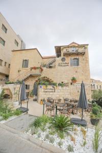 a patio with tables and umbrellas in front of a building at Farah Locanda in Ramallah