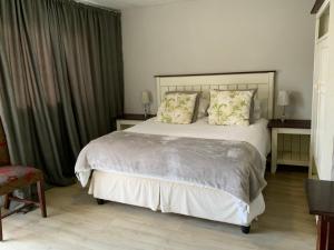 a bedroom with a large white bed with pillows at La Roche Stay in Port Elizabeth