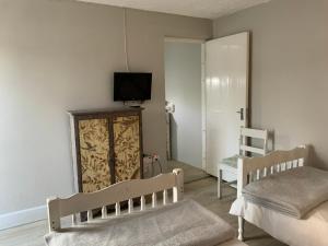 a bedroom with two beds and a tv on the wall at La Roche Stay in Port Elizabeth
