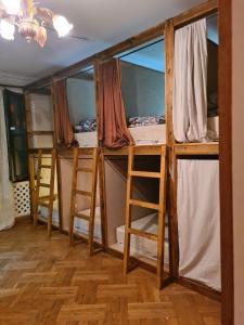 a room with four bunk beds and two chairs at Benevo Hostel in Tbilisi City