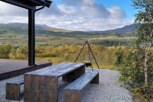 un banco con un columpio en la parte superior de una casa en Fjellhytte på hardangervidden med uforglemmelig utsikt!, en Garden