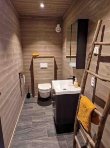 a wooden bathroom with a toilet and a sink at Fjellhytte på hardangervidden med uforglemmelig utsikt! in Garden