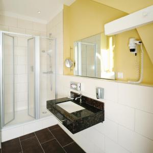 une salle de bain avec un lavabo et une douche dans l'établissement Bildungshaus St. Bernhard - Wohnen und Tagen, à Rastatt