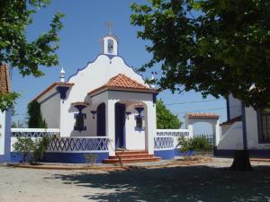 una pequeña iglesia blanca con una cruz en la parte superior en Apartamento das Bolotas., en Lavre