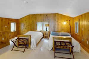 a bedroom with two beds and two chairs in it at Stoneybrook Retreat Haven in State Landing