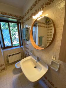 a bathroom with a sink and a mirror on the wall at Casa Loria - Appartamento con Giardino in San Martino di Castrozza