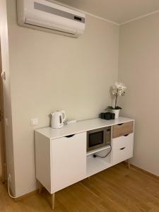 une cuisine blanche avec un four micro-ondes sur un comptoir dans l'établissement Lovely Aisa studio in Pärnu, à Pärnu