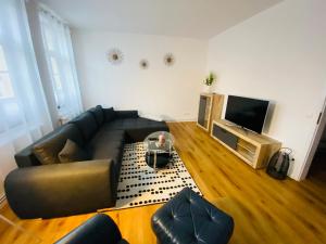 a living room with a couch and a flat screen tv at FeWo Meeresstern in Wismar
