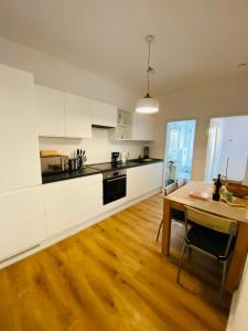 a kitchen with white cabinets and a wooden table at FeWo Meeresstern in Wismar