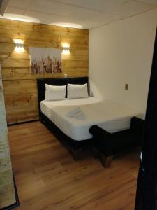 a bedroom with a bed with a wooden wall at Santa María Express in Santiago