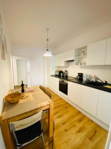 a kitchen with a wooden table and white cabinets at FeWo Meeresstern in Wismar