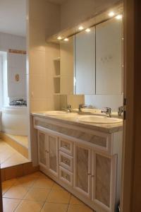 a bathroom with two sinks and a large mirror at Gîte Fleurs de Gamay au coeur du Beaujolais in Lancié