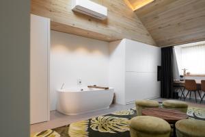 uma casa de banho com uma banheira, um lavatório e cadeiras em B&B Herenhuis em Izegem