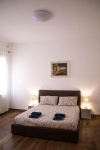 um quarto com uma cama com duas toalhas pretas em Beocio Home • The hidden gem in Murano’s heart em Murano