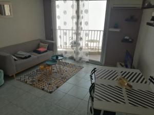un salon avec un canapé et une table dans l'établissement Joli studio bord de mer, clim, balcon, parking privé, à Menton