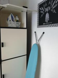 une planche de surf suspendue sur un mur à côté d'un placard dans l'établissement Joli studio bord de mer, clim, balcon, parking privé, à Menton 8 autres photos