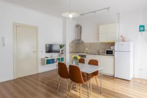 cocina blanca con mesa y sillas en New Apartament, en Tirana