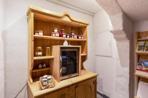Cette chambre dispose d'une étagère en bois et d'une télévision. dans l'établissement Florerhof Ferienwohnung Flieder, à Vols am Schlern