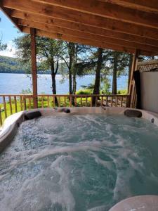 a hot tub in a cabin with a view of the water at Alison On Lake & Romantic Getaway With Private Hot Tub in Rivière-Rouge