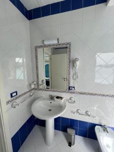 La salle de bains est pourvue d'un lavabo et d'un miroir. dans l'établissement Vient Mpop con terrazza vista mare, à Meta