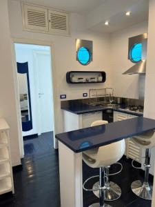 una cocina con encimera azul y taburetes en Vient Mpop con terrazza vista mare, en Meta
