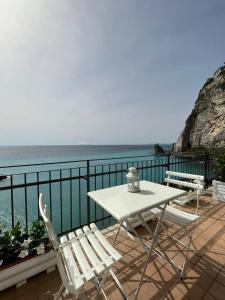 d'une table et de chaises sur un balcon donnant sur l'océan. dans l'établissement Vient Mpop con terrazza vista mare, à Meta