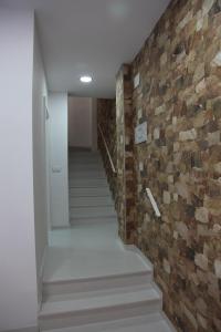 un couloir avec un mur en briques et des escaliers dans l'établissement Apartamentos Alogia, Pastora, Yerbater, à Segorbe