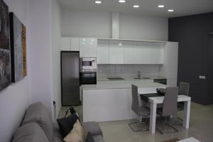 Apartamentos Alogia, Pastora, Yerbater في سيجوربي: مطبخ مع أريكة وطاولة وموقد